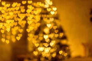 A lot of golden lights in the shape of hearts in the defocus on a dark background photo