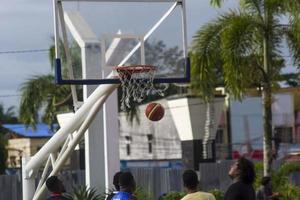 Sorong, West Papua, Indonesia, November 28th 2021. The activities at Aimas town square in Sunday morning. People playing basketball photo