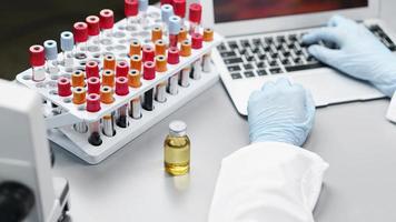Investigadora de laboratorio con tubos de ensayo de botella de vacuna foto