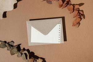 top view stationery envelope with dried leaves photo