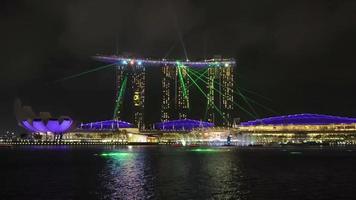 The Marina Bay Sands waterfront in Singapore is lit up in a magnificent Laser display show at night.