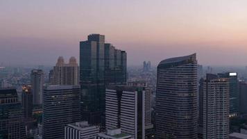 El lapso de tiempo del día a la noche muestra un edificio moderno en el centro de la ciudad de Bangkok en Tailandia
