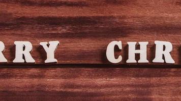 Merry Christmas lettering on wooden background. video