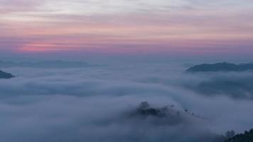 incroyable laps de temps de la brume naturelle se déplaçant à travers les montagnes pendant le lever du soleil le matin.