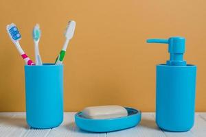 Cepillos de dientes jabón dispensador de jabón botella escritorio blanco contra la pared foto