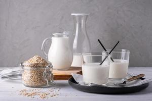 Various glass serving vessels with oat milk and oatmeal containers photo