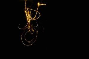 Círculo abstracto rastro de luz dorada espiral brillante efecto de luz elegante en un negro. foto