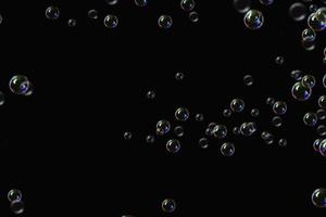 burbujas transparentes patrón de jabón superposición partículas abstractas salpicaduras de agua en negro. foto