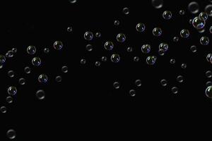 transparent bubbles soap pattern overlay abstract particles splashes of water on black. photo