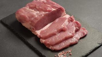 Raw pork steak on a cutting board with herbs and spices video