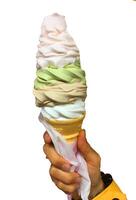 ice cream rainbow flavor frozen dessert pattern in brown waffle cone hand holding on white. photo