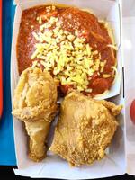 Fresh delicious crispy fried chicken golden brown with red sauce spaghetti on white box. photo