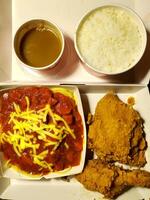 Fresh delicious crispy fried chicken golden brown with red sauce spaghetti on white box. photo