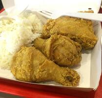 Fresh delicious crispy fried chicken golden brown with white rice on white box. photo