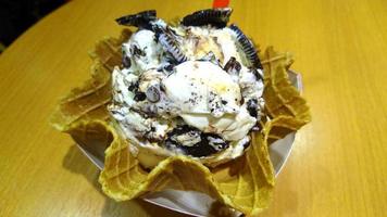 ice cream vanilla and chocolate flavor frozen dessert pattern in waffle cup on wood. photo