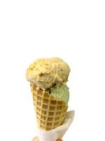 ice cream flavor white chocolate frozen dessert pattern in waffle cone hand holding on table. photo