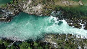 luchtfoto van een schone, heldere en frisse bergrivier. bovenaanzicht van een heldere groene rivier in de buurt van de bron. filmische drone-opname van de natuur. video