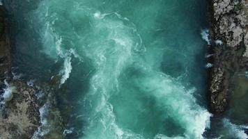 luchtfoto van een schone, heldere en frisse bergrivier. bovenaanzicht van een heldere groene rivier in de buurt van de bron. filmische drone-opname van de natuur. video