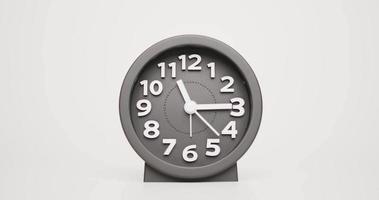 Front view, Show time from eleven o'clock to twelve o'clock. Drark gray modren clock. On the white background. video