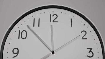 Nahaufnahme, Zeitraffer, weiße Wanduhr mit kurzen Zeigern, die zwölf Uhr zeigen. es ist Zeit für eine Pause. auf weißem Hintergrund. video