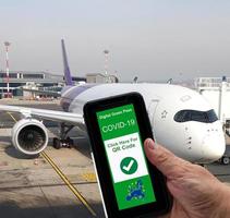 Digital green pass Covid19 of EU on smartphone held by hand with a commercial airliner in the background. Safe travelling Concept photo