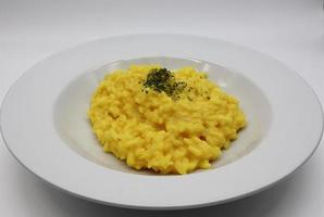 Italian Risotto allo Zafferano, rice with saffron, in a white dish