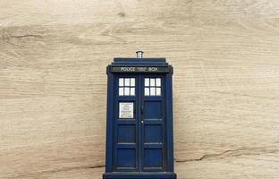 Police call box isolated on wooden background. Tardis from Doctor Who. Top view with copy space for your text. photo