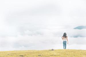 Woman relaxed walks towards the cloudscape in pristine nature. concept of freedom and life