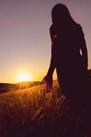 Girl with sunrise in meadow field in summer photo