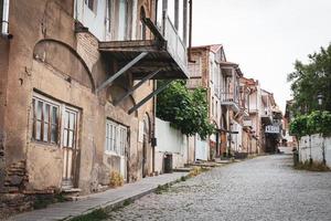 Old wooden balcony and historical connected georgian houses with street view in Telavi city in Georgia. photo