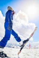 Caucasian young woman in blue outfit look up to the blank sky. Ski holiday capture social media vertical promo vertical background photo