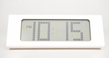 lapso de tempo, relógio digital branco, o tempo passa rapidamente. o relógio indica a hora da uma hora. no fundo branco.