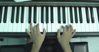 Ansicht von oben, Finger drücken die Tasten auf dem Klavier. zu Hause Klavier spielen.