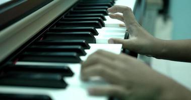närbild, fingrar trycker på tangenterna på pianot. spela piano hemma. video