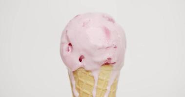 de cerca, fusión de helado con sabor a fresa en el cono. el flujo después de que el helado se haya derretido. sobre el fondo blanco.