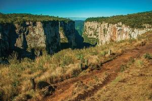 camino de tierra a un lado del cañón de itaimbezinho con escarpados acantilados rocosos cerca de cambara do sul. una pequeña ciudad rural en el sur de Brasil con increíbles atractivos turísticos naturales. foto retocada.