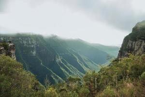 Fortaleza cañón con escarpados acantilados rocosos cubiertos por un espeso bosque y niebla que sube por el barranco cerca de cambara do sul. una pequeña ciudad rural en el sur de Brasil con increíbles atractivos turísticos naturales. foto