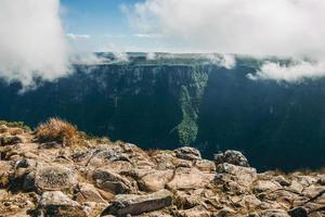 Fortaleza Canyon with steep rocky cliffs and mist coming up in the other side of valley near Cambara do Sul. A small country town in southern Brazil with amazing natural tourist attractions. photo