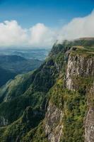 Fortaleza Canyon with steep rocky cliffs covered by thick forest in a cloudy day near Cambara do Sul. A small country town in southern Brazil with amazing natural tourist attractions. photo