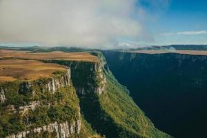 Fortaleza cañón formado por escarpados acantilados rocosos con bosque y meseta plana cubierta por arbustos secos cerca de cambara do sul. una pequeña ciudad rural en el sur de Brasil con increíbles atractivos turísticos naturales. foto