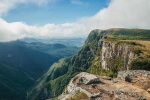 Fortaleza Canyon with steep rocky cliffs covered by thick forest in a cloudy day near Cambara do Sul. A small country town in southern Brazil with amazing natural tourist attractions. photo