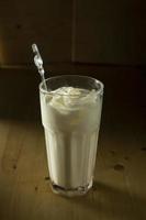 A glass of milk with ice on a wooden table photo