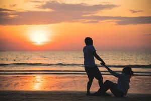Amantes asiáticos felices y divirtiéndose tomados de la mano. viajar playa vacaciones de verano. foto