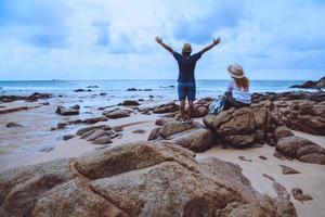 Amante asiático mujer y hombre viajan por la naturaleza. viajar relajarse. en las rocas en el mar. en el verano. tailandia foto