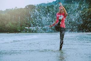 asian woman jogging workout on the beach in the morning. Relax with the beach. fun and happy with playing, jumping, kicking the sea. in summer photo