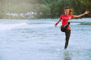 asian woman jogging workout on the beach in the morning. Relax with the beach. fun and happy with playing, jumping, kicking the sea. in summer photo