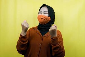 mujer musulmana con máscara, puños cerrados, puñetazos de manos, manos de signo de victoria, espíritu, prevenir el virus de la corona, prevenir el covid-19, aislado foto