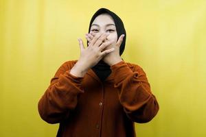 Beautiful young asian muslim woman shocked, surprised, disbelieving, getting shocking information, with hands covering mouth isolated