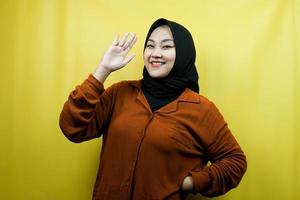 Beautiful and cheerful young asian muslim woman, with open palms, saying hello, how are you, isolated photo