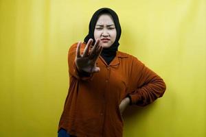 Beautiful young asian muslim woman with serious expression, refusing something, looking at camera isolated photo